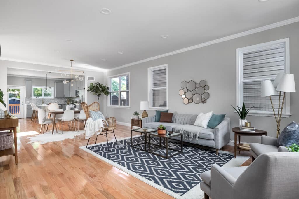 A large living space features hardwood floors that open up into a dining area and kitchen.