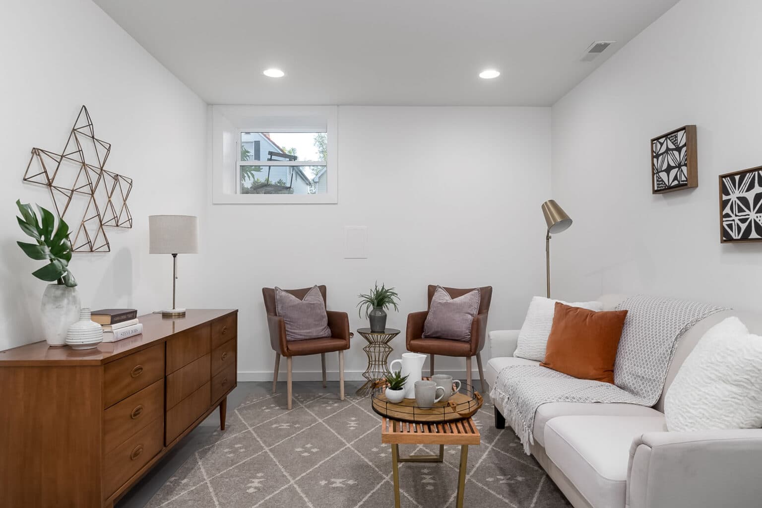 A sitting area with two chairs, couch, coffee table, and decorations.